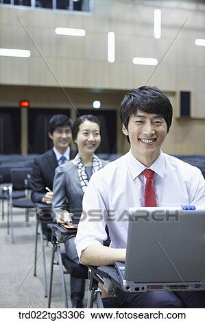 Stock Photograph - Businessmen listening to the seminar in the auditorium. Fotosearch