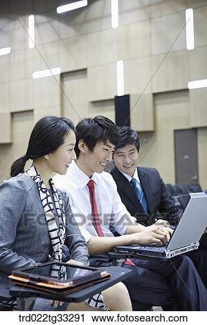 Businessmen looking at the laptop in the auditorium View Large Photo Image Stock Image - Businessmen looking at the laptop in the auditorium. Fotosearch