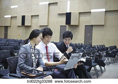 Businessmen looking at the laptop in the auditorium View Large Photo Image Stock Photo - Businessmen looking at the laptop in the auditorium. Fotosearch
