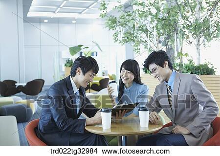 Businessmen looking at the planner in the lounge View Large Photo Image Picture - Businessmen looking at the planner in the lounge. Fotosearch