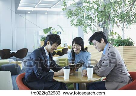 Stock Image - Businessmen looking at the planner in the lounge. Fotosearch