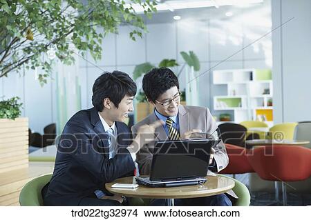 Picture - Businessmen looking at the planner . Fotosearch