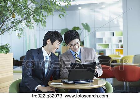 Stock Image - Businessmen looking at the planner . Fotosearch