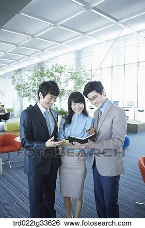 Stock Photograph - Businessmen looking at the planner . Fotosearch