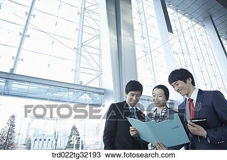 Businessmen looking over the document View Large Photo Image Stock Image - Businessmen looking over the document. Fotosearch