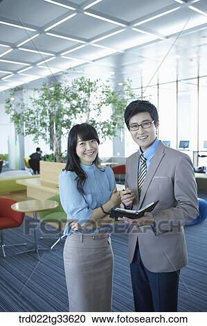 Stock Image - Businessmen smiling with the planner. Fotosearch