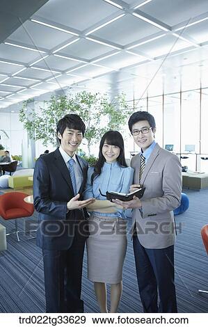Stock Photo - Businessmen smiling with the planner. Fotosearch