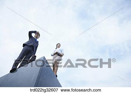 Stock Photo - Businessmen standing with briefcase and planner. Fotosearch