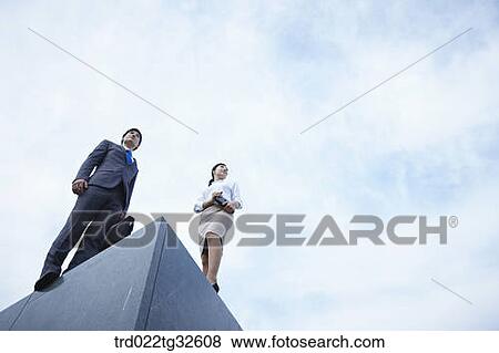 Stock Photo - Businessmen standing with briefcase and planner. Fotosearch