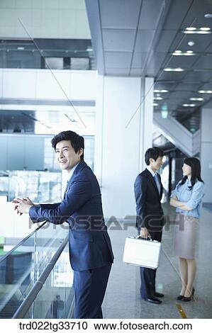 Businessmen taking a break in the hallway View Large Photo Image Stock Image - Businessmen taking a break in the hallway. Fotosearch