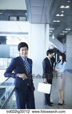 Stock Image - Businessmen taking a break in the hallway. Fotosearch