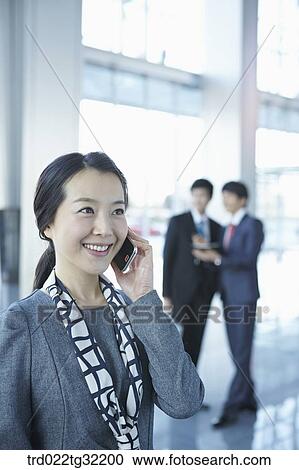 Stock Image - Businessmen talking on the phone and having a talk. Fotosearch