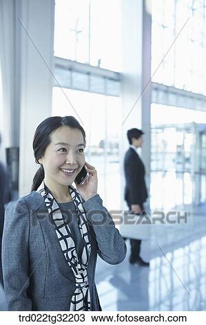 Stock Image - Businessmen talking on the phone and passing by . Fotosearch