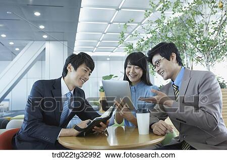 Stock Image - Businessmen talking with the planner and tablet PC. Fotosearch