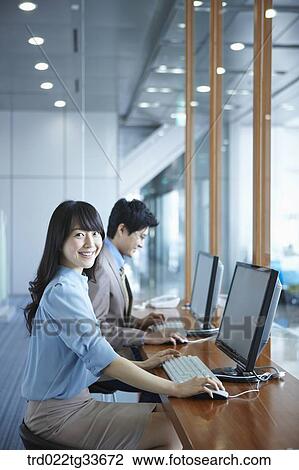 Stock Image - Businessmen using computer in the lounge. Fotosearch