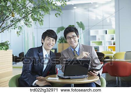 Stock Image - Businessmen working in the lounge. Fotosearch