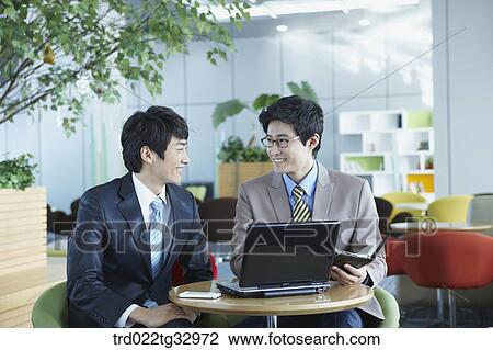Stock Image - Businessmen working in the lounge. Fotosearch