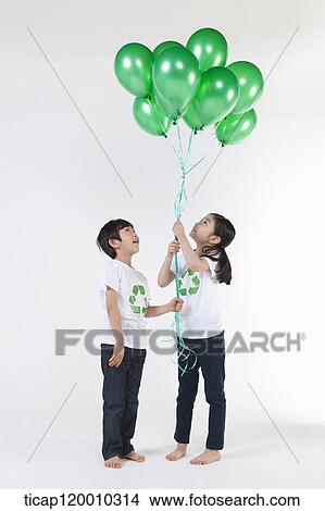 Children wearing recycling shirt with green balloons View Large Photo Image Picture - Children wearing recycling shirt with green balloons. Fotosearch