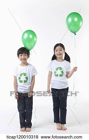 Stock Photo - Children wearing recycling shirt with green balloons. Fotosearch