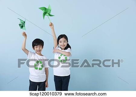 Stock Photo - Children wearing recycling shirt with green pinwheel. Fotosearch