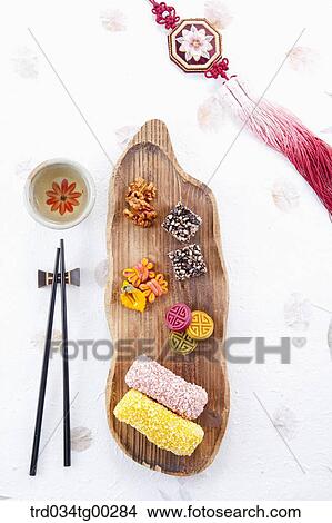 Picture - Colorful Korean dessert, a cup of tea, chopsticks, and clothes accessory . Fotosearch