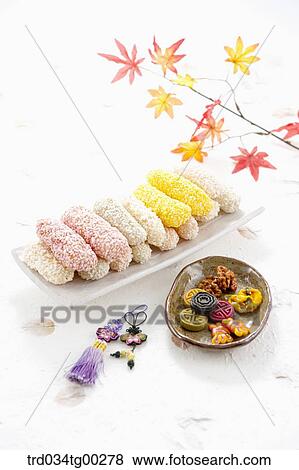 Colorful Korean dessert on dish with clothes accessory and colored leaves around View Large Photo Image Stock Photo - Colorful Korean dessert on dish with clothes accessory and colored leaves around. Fotosearch