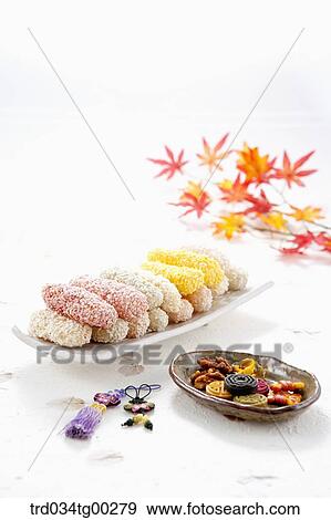 Stock Photo - Colorful Korean dessert on dish with clothes accessory and colored leaves around. Fotosearch
