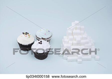 Stock Photo - Cupcake and pile of cube sugar. Fotosearch