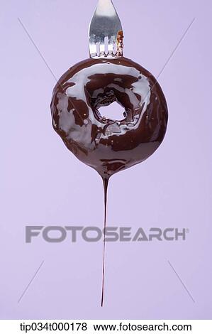 Donut dripping chocolate with fork View Large Photo Image Stock Photo - Donut dripping chocolate with fork. Fotosearch