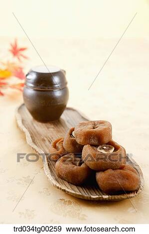 Dried persimmons and small jar on wooden dish View Large Photo Image Stock Photo - Dried persimmons and small jar on wooden dish . Fotosearch
