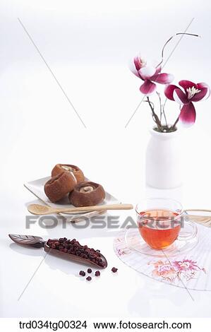 Picture - Dries persimmons and fruit, a cup of tea, a fan, and flowers. Fotosearch