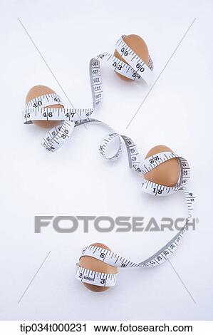 Stock Image - Eggs tied with measuring tape. Fotosearch