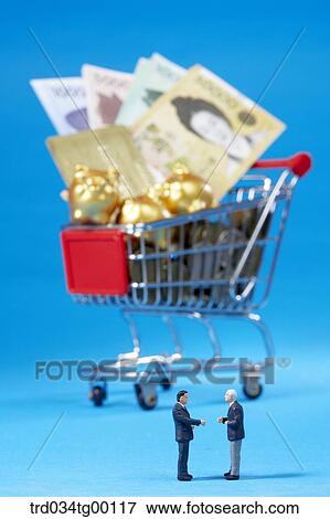 figures stood beside the shopping cart which has money and credit card and piggy bank View Large Photo Image Stock Photo - figures stood beside the shopping cart which has money and credit card and piggy bank. Fotosearch