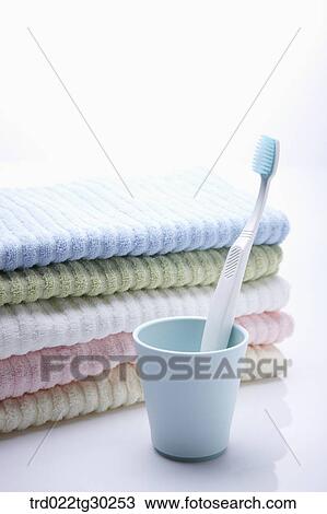 Folded colorful towels and a tooth brush in cup View Large Photo Image Stock Image - Folded colorful towels and a tooth brush in cup . Fotosearch