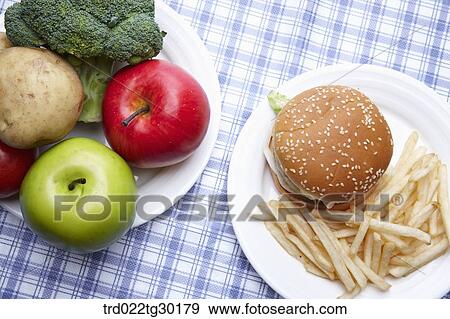 Stock Photo - Fresh vegetable and junk food on dish . Fotosearch