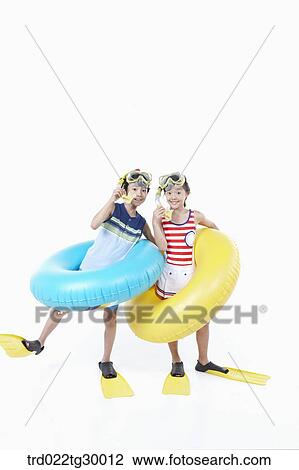 Stock Image - girl and boy are wearing snorkels and tube and flippers. Fotosearch