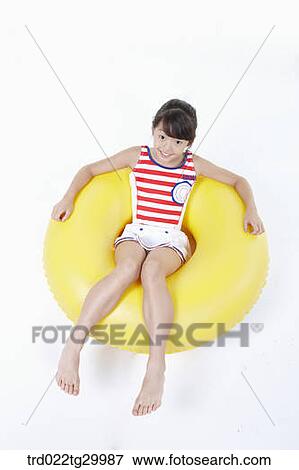 Stock Photo - girl is sitting on the tube. Fotosearch