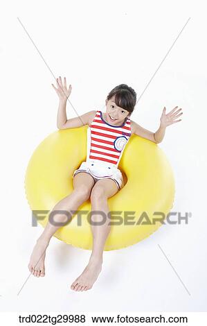 Stock Photo - girl is sitting on the tube. Fotosearch