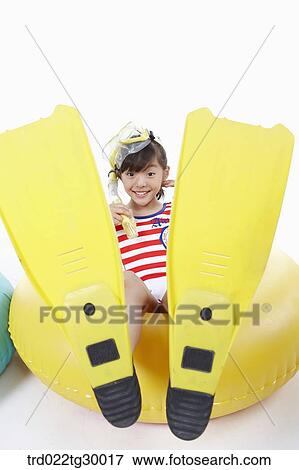 Stock Photo - girl is sitting on the tube with snorkel and flippers. Fotosearch