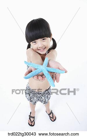 girl stretched her arms out with starfish View Large Photo Image Stock Image - girl stretched her arms out with starfish. Fotosearch
