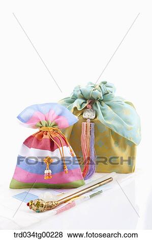Gold traditional hair accessory, patched luck bag, and gold wrapped package View Large Photo Image Stock Photo - Gold traditional hair accessory, patched luck bag, and gold wrapped package. Fotosearch