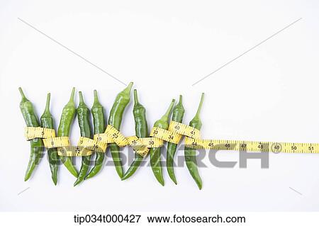 Stock Photo - Green peppers tied with a measuring tape . Fotosearch