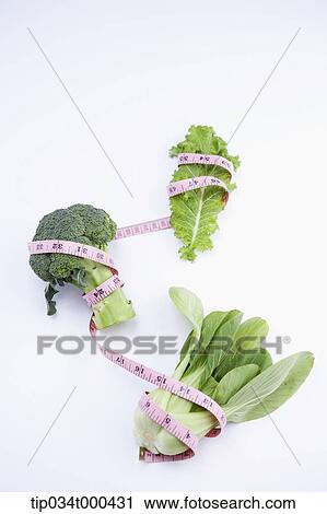 Stock Image - Green vegetable tied with a measuring tape. Fotosearch