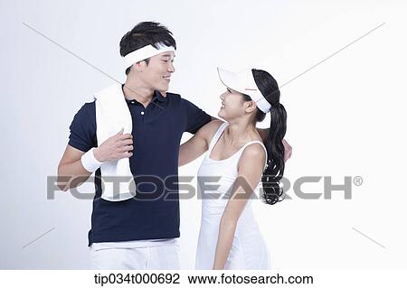 Stock Image - Male and female tennis players facing together. Fotosearch