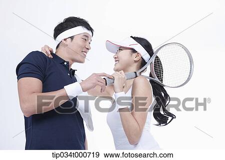Stock Photo - Male and female tennis players facing together. Fotosearch
