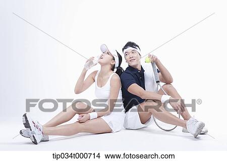 Picture - Male and female tennis players taking a break. Fotosearch