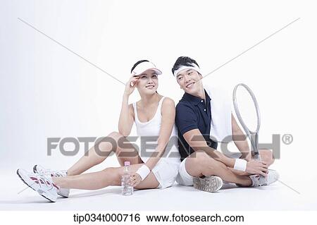 Stock Photograph - Male and female tennis players taking a break. Fotosearch