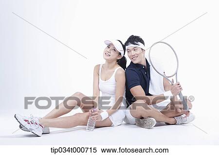 Stock Photography - Male and female tennis players taking a break. Fotosearch