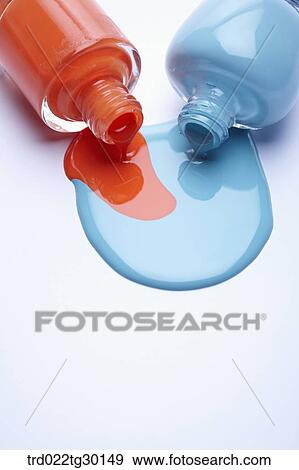 Stock Photo - Orange and blue nail polish from fallen bottles . Fotosearch