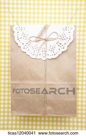 Stock Image - Paper gift package with white lace paper. Fotosearch